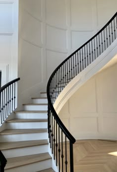 a white staircase with black railing and handrail