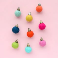 several different colored balls on a pink background