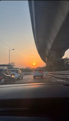 the sun is setting behind some cars driving down the highway in traffic jams on their way to work