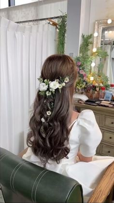 a woman sitting in front of a mirror wearing a flower crown