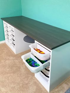 a kitchen counter with two bins on it and some food in the bottom drawer