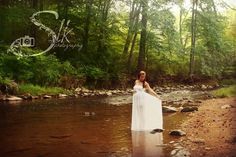 a woman in a white dress is standing in the water