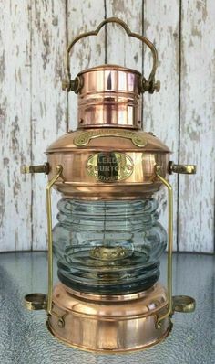 an old fashioned brass and glass lantern on a table