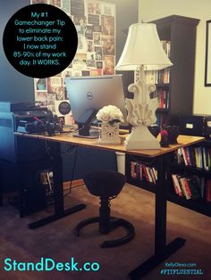 a desk with a computer on it in front of a book shelf filled with books