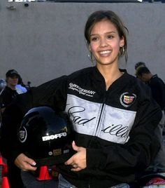 a woman holding a motorcycle helmet in her hands