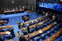 people are standing in the middle of a room with blue chairs and screens on the walls