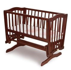 a wooden baby crib with white sheets on the bottom and sides, in front of a white background