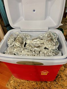 a red cooler with foil wrapped in aluminum foil