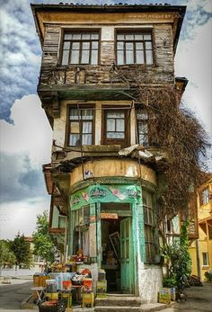 an old building with lots of windows and plants growing out of the top of it