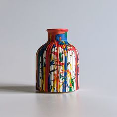 a colorful vase sitting on top of a white table