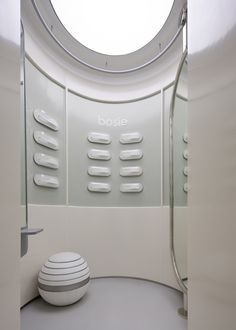 there is a round window in the bathroom with white walls and flooring on it