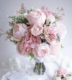 a bouquet of pink flowers sitting on top of a table