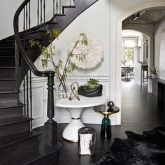 a white table sitting in the middle of a room next to a spiral stair case