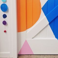 the door is painted bright blue, orange and pink with colorful circles on it's side