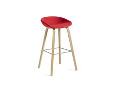 a red stool with wooden legs and a seat cushion on the bottom, in front of a white background