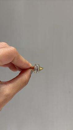 a person holding a tiny diamond ring in their hand