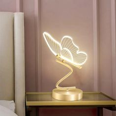 a light that is sitting on top of a table next to a bed in a room