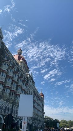 a very tall building with many windows on it's sides and a sign in the foreground