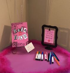 a pink table topped with lots of writing and markers