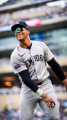 a baseball player is smiling while standing on the field