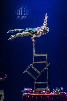 a man is doing tricks on top of a chair