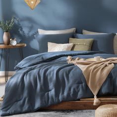 a bed with blue sheets and pillows in a room