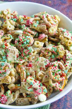 a bowl filled with cereal and sprinkles on top of a blue table cloth