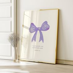 a framed photo with a purple bow on it next to a vase and window sill