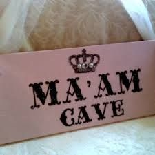 a pink sign that says ma'am cave with a crown on it