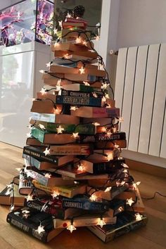 a christmas tree made out of books with lights on the top and one book in the middle