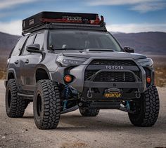 the front end of a gray toyota truck with four wheels on it's tires