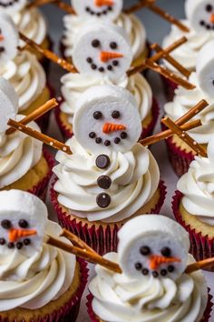 cupcakes with white frosting and chocolate candies in the shape of snowmen