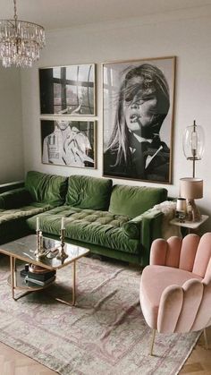 a living room with green couches and pictures on the wall above them, along with two pink chairs