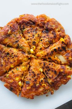 a close up of a pizza on a cutting board with corn and cheese toppings