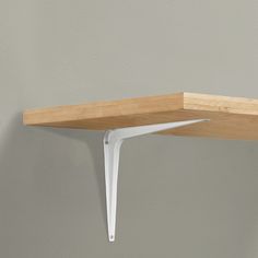 a wooden shelf with white brackets on it