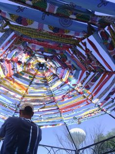 a man standing under a colorfully decorated umbrella