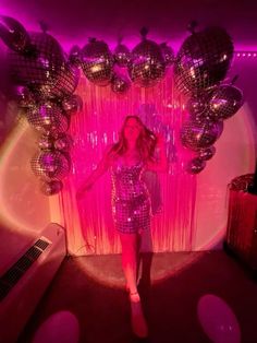 a woman standing in front of disco balls