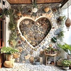 a heart shaped stone wall with potted plants on the side and other decorations around it