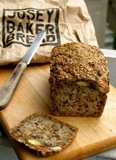 a loaf of bread sitting on top of a wooden cutting board next to a knife