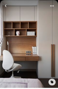 a white chair sitting in front of a desk with a book shelf on top of it