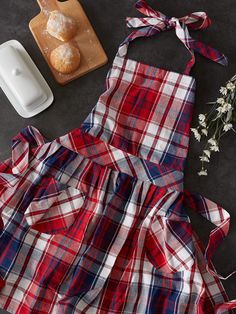 a red, white and blue plaid dress next to donuts on a cutting board