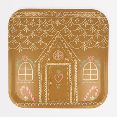 a brown paper plate with a gingerbread house on it