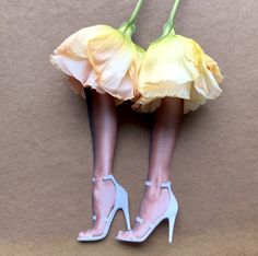 a woman's legs in high heels and a yellow flower on the bottom of her skirt