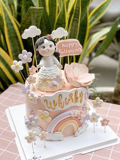 a birthday cake decorated with flowers and a girl on top