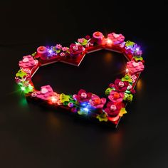 a heart shaped light up decoration with flowers and lights in the shape of a flower