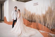 a bride and groom standing in front of a wall with the words swann chaun written on it