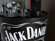 there is a black and white bucket with glasses on it that has jack daniels written on it