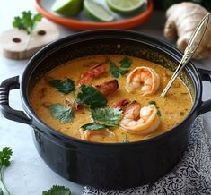 a bowl of soup with shrimp and cilantro