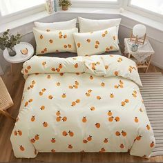 a bed with oranges on it in a room next to a table and chair