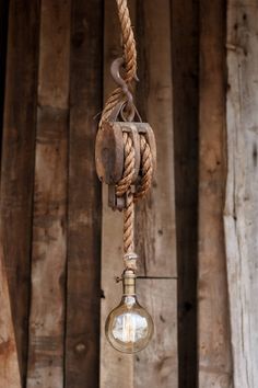 an old fashioned light bulb hanging from a rope